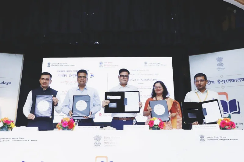 शिक्षा मंत्रालय और राष्ट्रीय पुस्तक न्यास के अधिकारी समझौते के दस्तावेज़ों के साथ